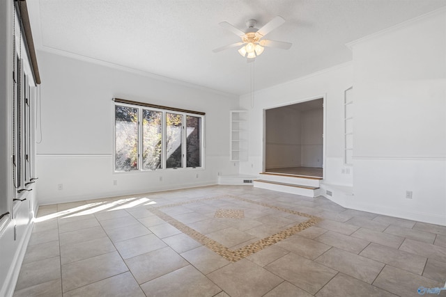 tiled spare room featuring built in shelves, crown molding, baseboards, a textured ceiling, and a ceiling fan