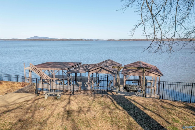 dock area with a gazebo, a yard, a water view, and fence