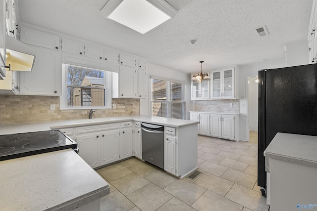 kitchen featuring stainless steel dishwasher, visible vents, freestanding refrigerator, and a sink