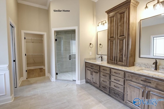 bathroom with ornamental molding, vanity, and an enclosed shower