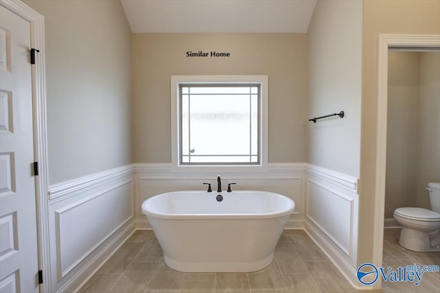 bathroom featuring tile patterned flooring, a bathtub, and toilet