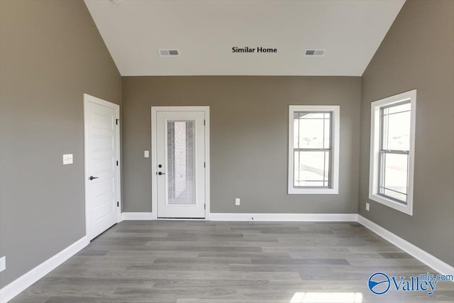 unfurnished room featuring high vaulted ceiling and light wood-type flooring
