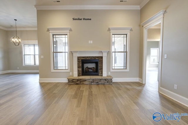unfurnished living room with hardwood / wood-style flooring, ornamental molding, an inviting chandelier, and a fireplace