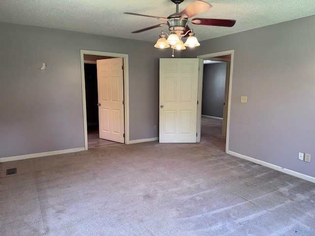 interior space with ceiling fan, carpet floors, and a textured ceiling