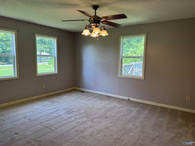 unfurnished room featuring ceiling fan, plenty of natural light, and a textured ceiling