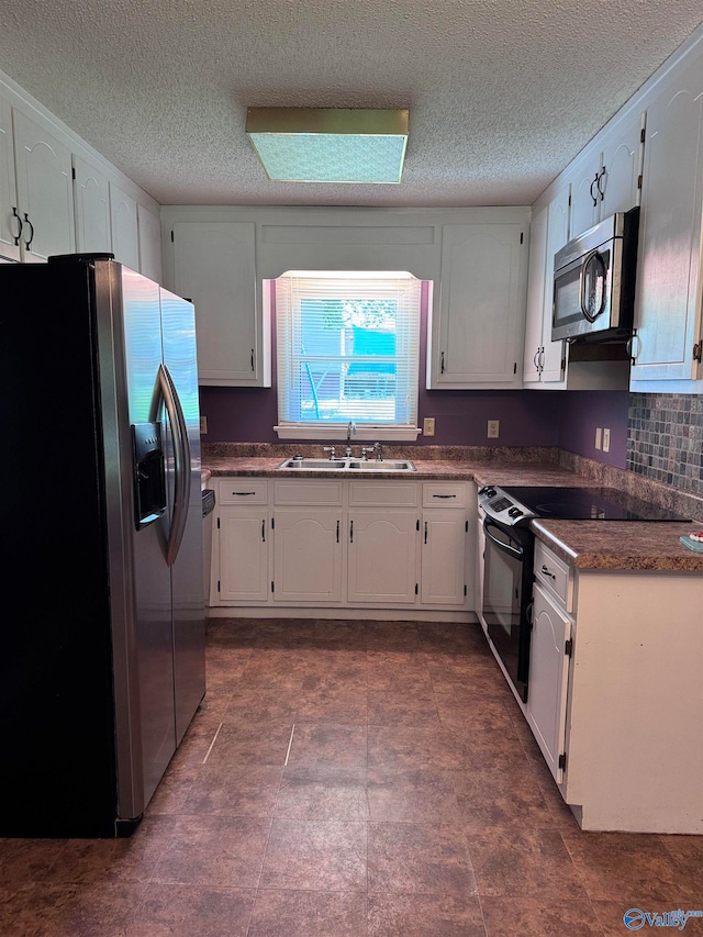 kitchen featuring white cabinets, a skylight, appliances with stainless steel finishes, sink, and a textured ceiling