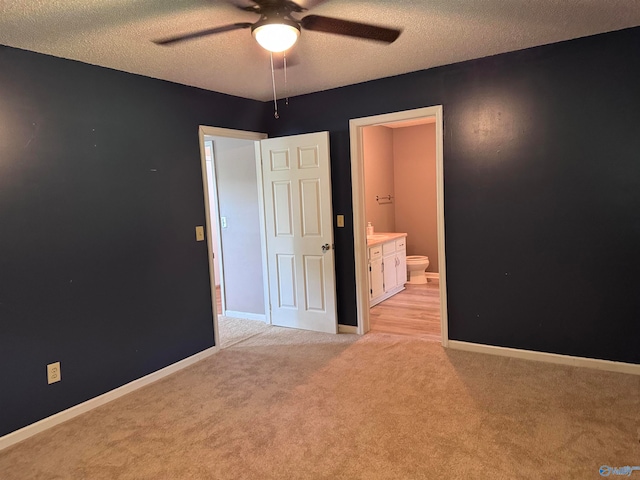 spare room with a textured ceiling, ceiling fan, and light carpet