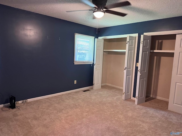 unfurnished bedroom with a textured ceiling, carpet, and ceiling fan