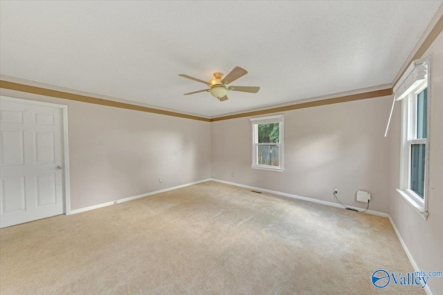 carpeted spare room featuring a textured ceiling and ceiling fan