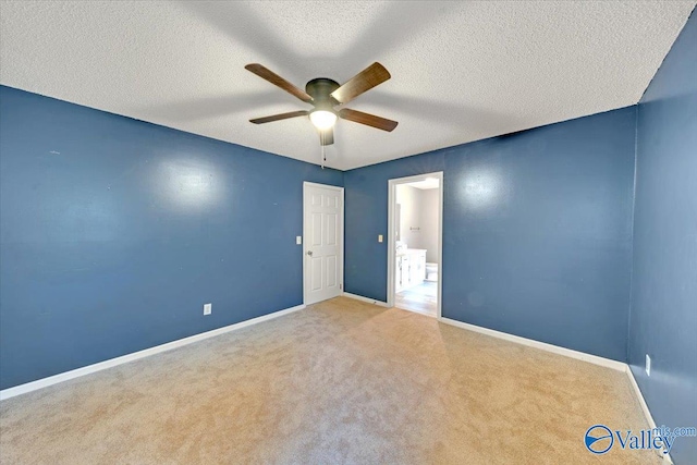 carpeted spare room featuring ceiling fan and a textured ceiling