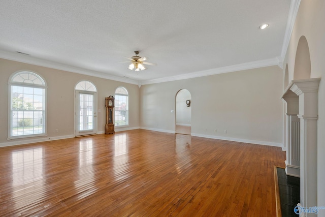 unfurnished living room with visible vents, baseboards, a ceiling fan, crown molding, and light wood-type flooring