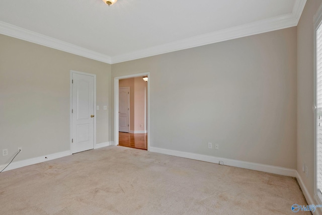 carpeted spare room featuring baseboards and ornamental molding