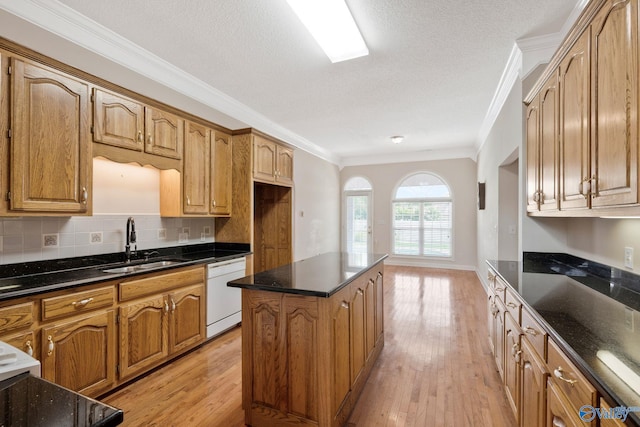 kitchen featuring decorative backsplash, white dishwasher, crown molding, light wood-style floors, and a sink