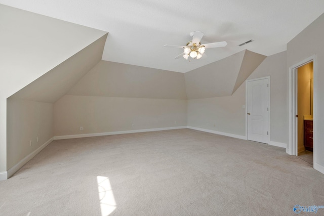 additional living space featuring lofted ceiling, ceiling fan, light carpet, visible vents, and baseboards