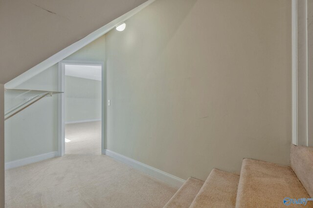 stairway with carpet flooring, vaulted ceiling, and baseboards