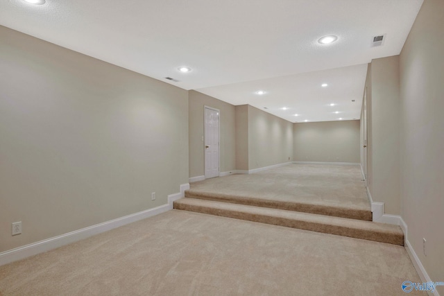 stairway featuring baseboards, visible vents, and carpet flooring