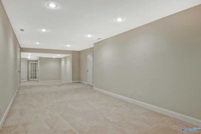 spare room featuring recessed lighting, baseboards, and light colored carpet