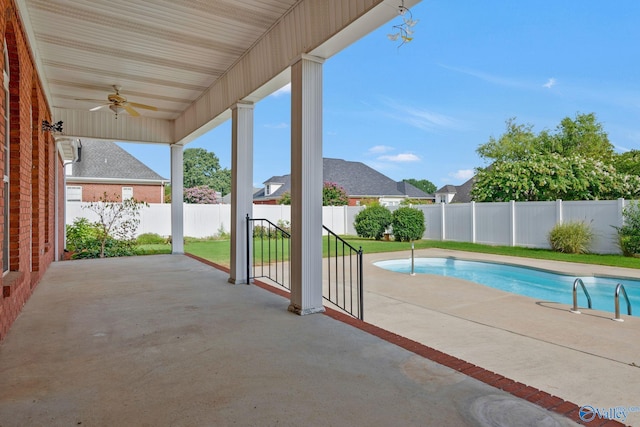 view of swimming pool with ceiling fan, a fenced backyard, a lawn, a fenced in pool, and a patio area