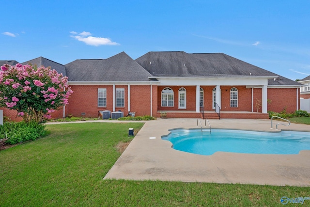 outdoor pool with central air condition unit, a yard, and a patio