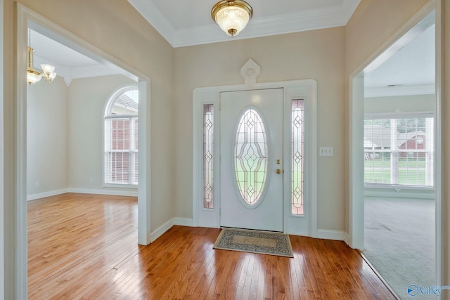 foyer entrance with ornamental molding, hardwood / wood-style flooring, a wealth of natural light, and baseboards