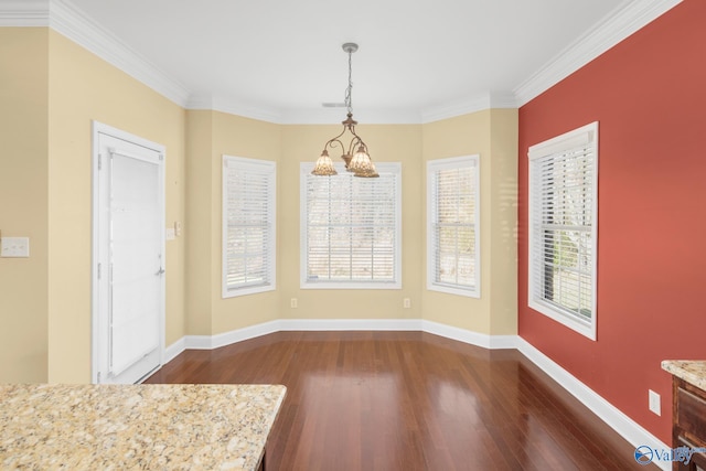 unfurnished dining area with dark hardwood / wood-style floors, an inviting chandelier, and crown molding