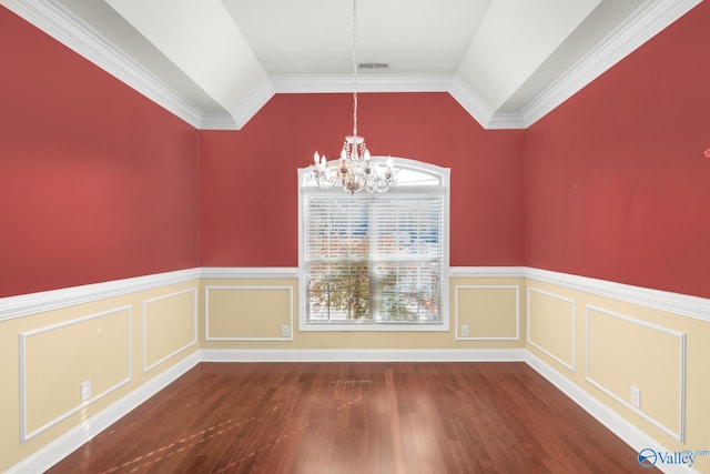 unfurnished dining area with a notable chandelier, dark wood-type flooring, vaulted ceiling, and ornamental molding