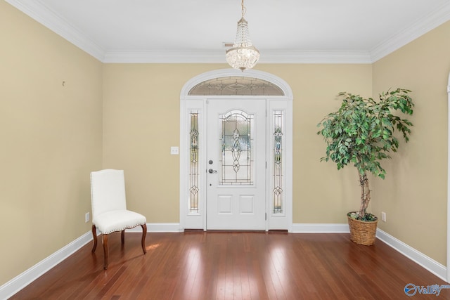 entryway with a notable chandelier, dark hardwood / wood-style floors, and ornamental molding