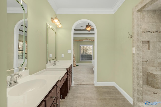 bathroom featuring tiled shower, vanity, ceiling fan, and crown molding