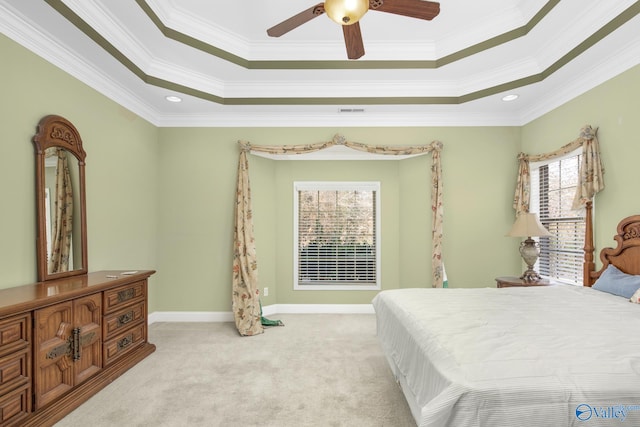 carpeted bedroom with ceiling fan, crown molding, a tray ceiling, and multiple windows