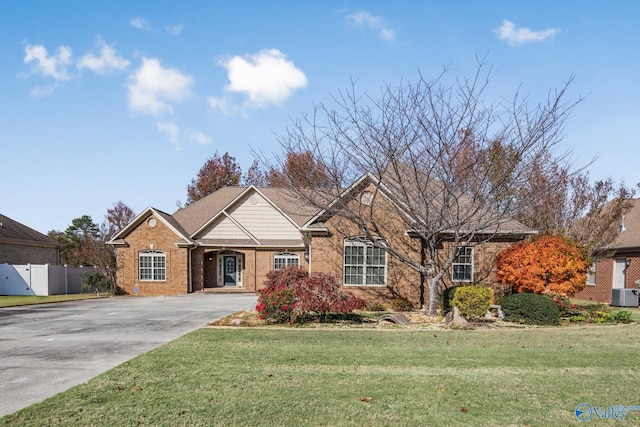 view of front of property with central AC unit and a front lawn