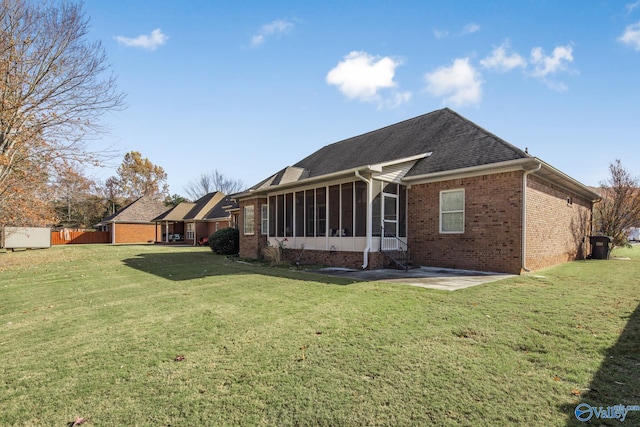 back of property featuring a lawn, a sunroom, and a patio