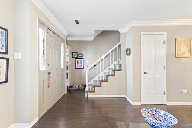 foyer featuring visible vents, wood finished floors, crown molding, baseboards, and stairs