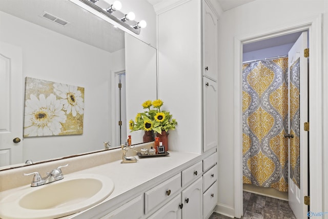 full bath featuring a shower with shower curtain, visible vents, wood finished floors, and vanity