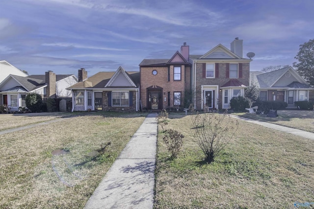 view of front facade featuring a front lawn, brick siding, and a chimney