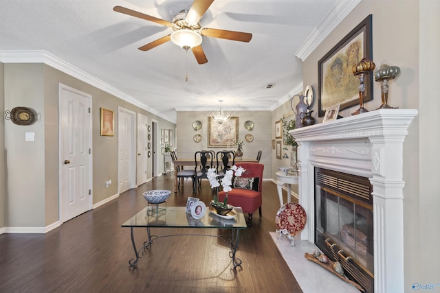 living area with baseboards, a fireplace with flush hearth, ornamental molding, ceiling fan with notable chandelier, and wood finished floors