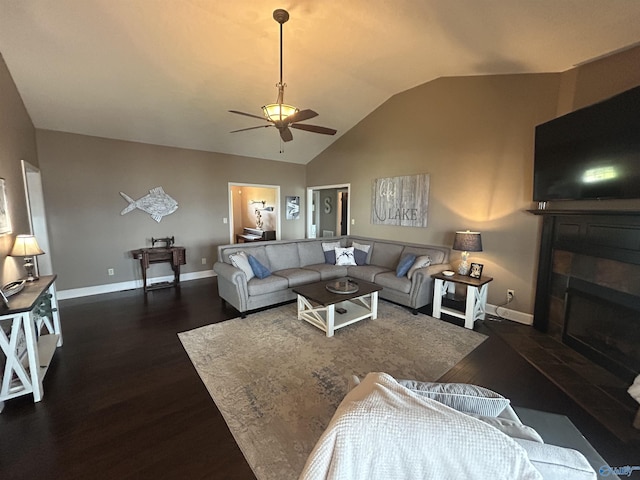 living area featuring vaulted ceiling, a fireplace, wood finished floors, and baseboards