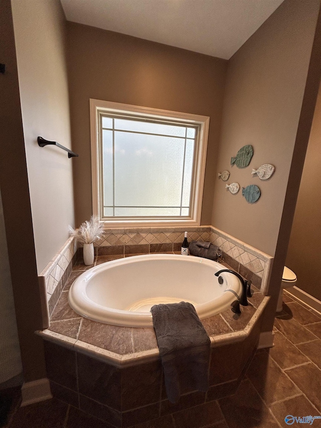 bathroom with toilet, a garden tub, and tile patterned flooring