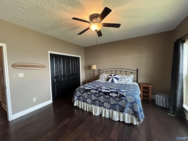 bedroom with a textured ceiling, wood finished floors, a ceiling fan, baseboards, and a closet