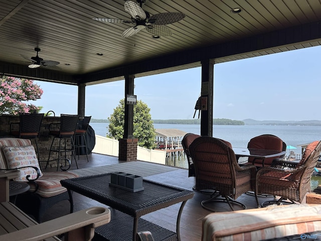 wooden terrace with ceiling fan and a water view