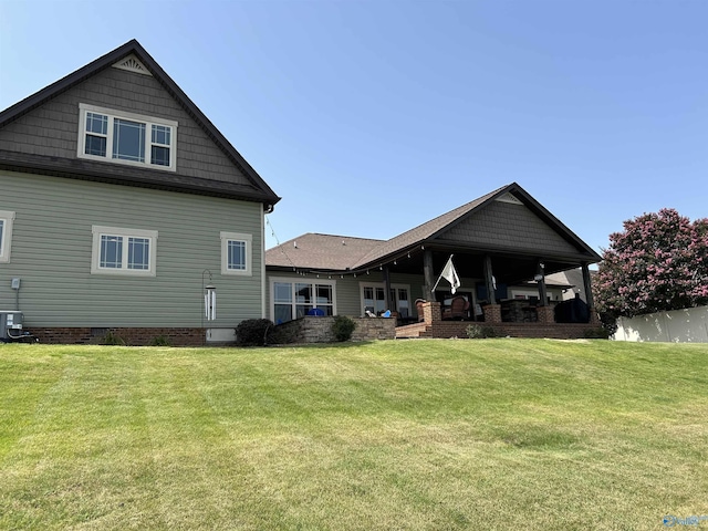 back of house with central AC and a lawn