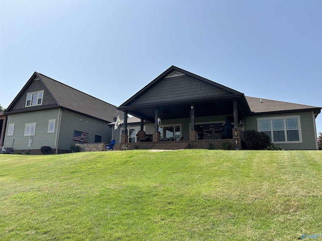 back of house featuring covered porch, a yard, and central AC unit