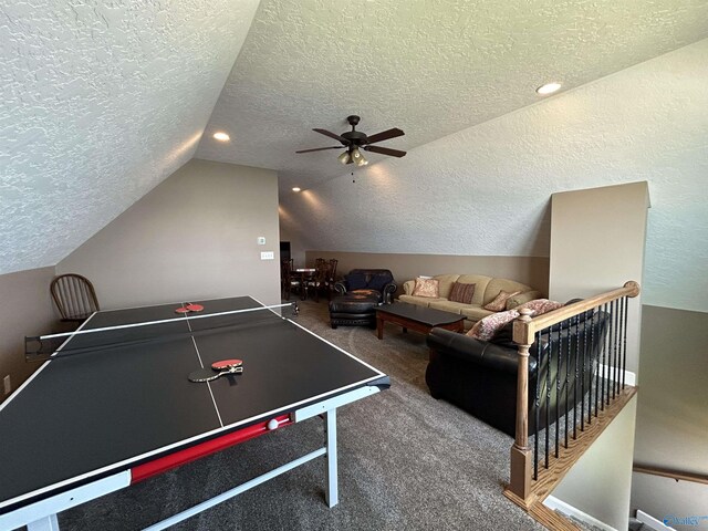 playroom with ceiling fan, carpet, vaulted ceiling, and a textured ceiling