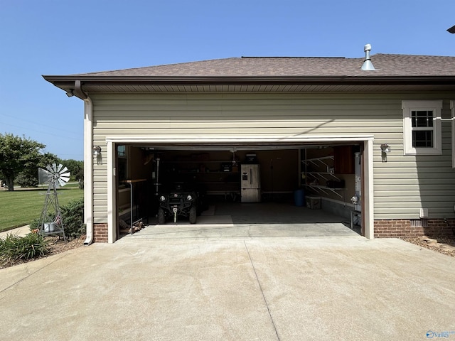 garage featuring driveway and stainless steel fridge