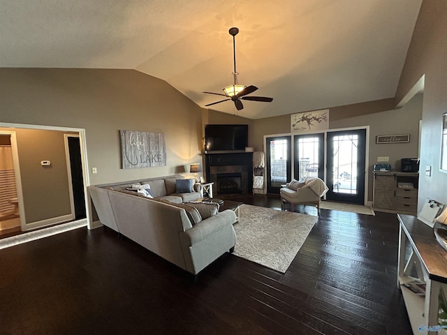 living room featuring baseboards, dark wood finished floors, lofted ceiling, ceiling fan, and a fireplace