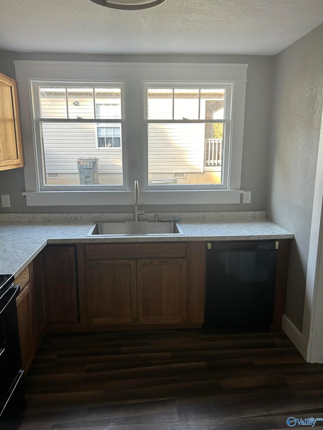 kitchen with black appliances, dark wood-type flooring, sink, and a textured ceiling