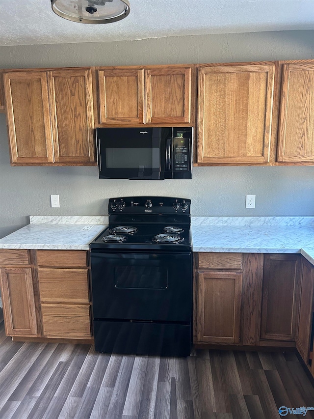 kitchen featuring dark wood-type flooring and black appliances