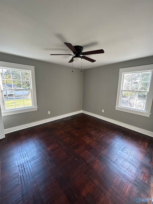 spare room with ceiling fan, plenty of natural light, and dark hardwood / wood-style flooring