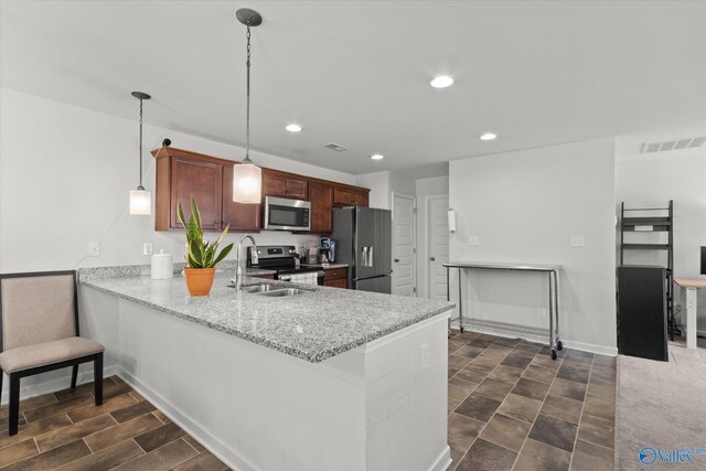 kitchen with stainless steel appliances, decorative light fixtures, light stone counters, dark tile patterned floors, and kitchen peninsula