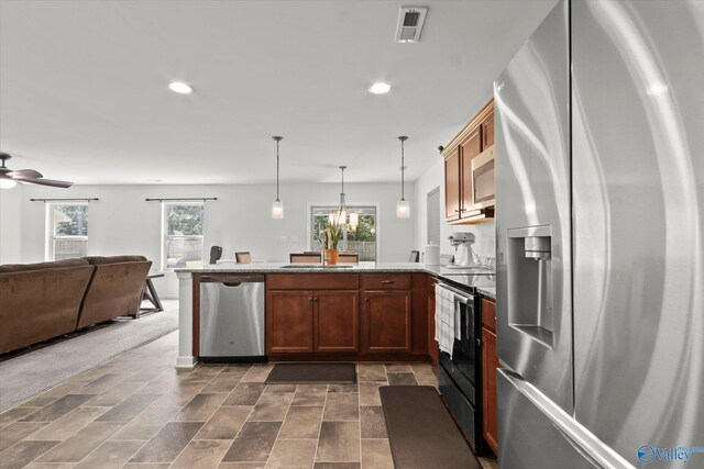 kitchen featuring plenty of natural light, stainless steel appliances, kitchen peninsula, and ceiling fan