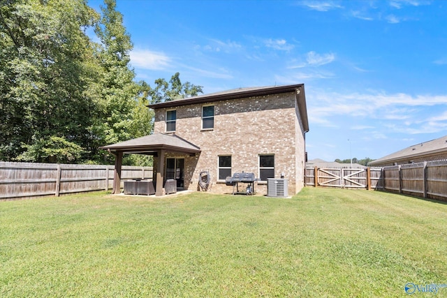 back of house featuring a yard, central AC, and a patio